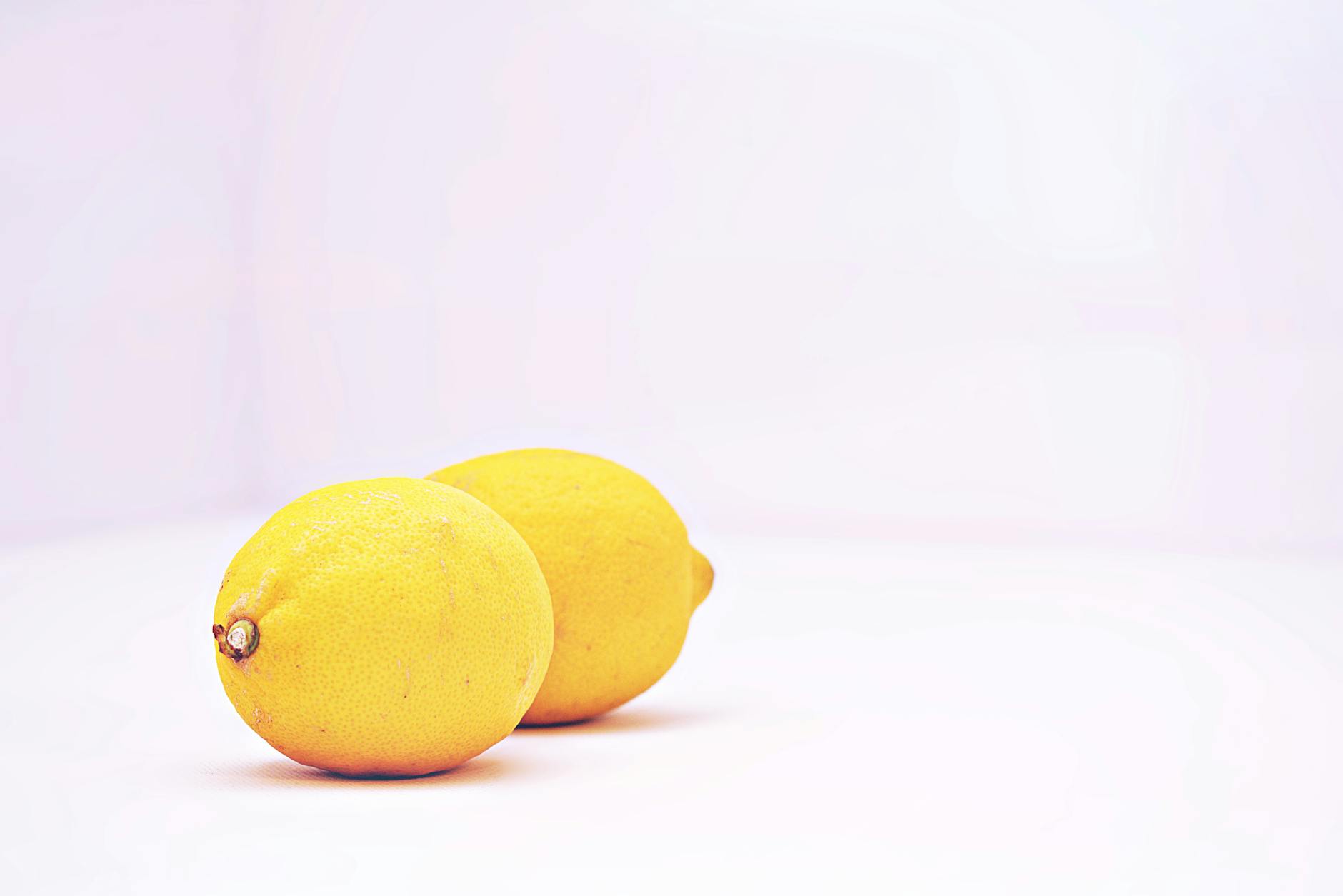Two vibrant lemons on a white background, representing the Hello Nancy's Lemons lemon clitoral vibrator
