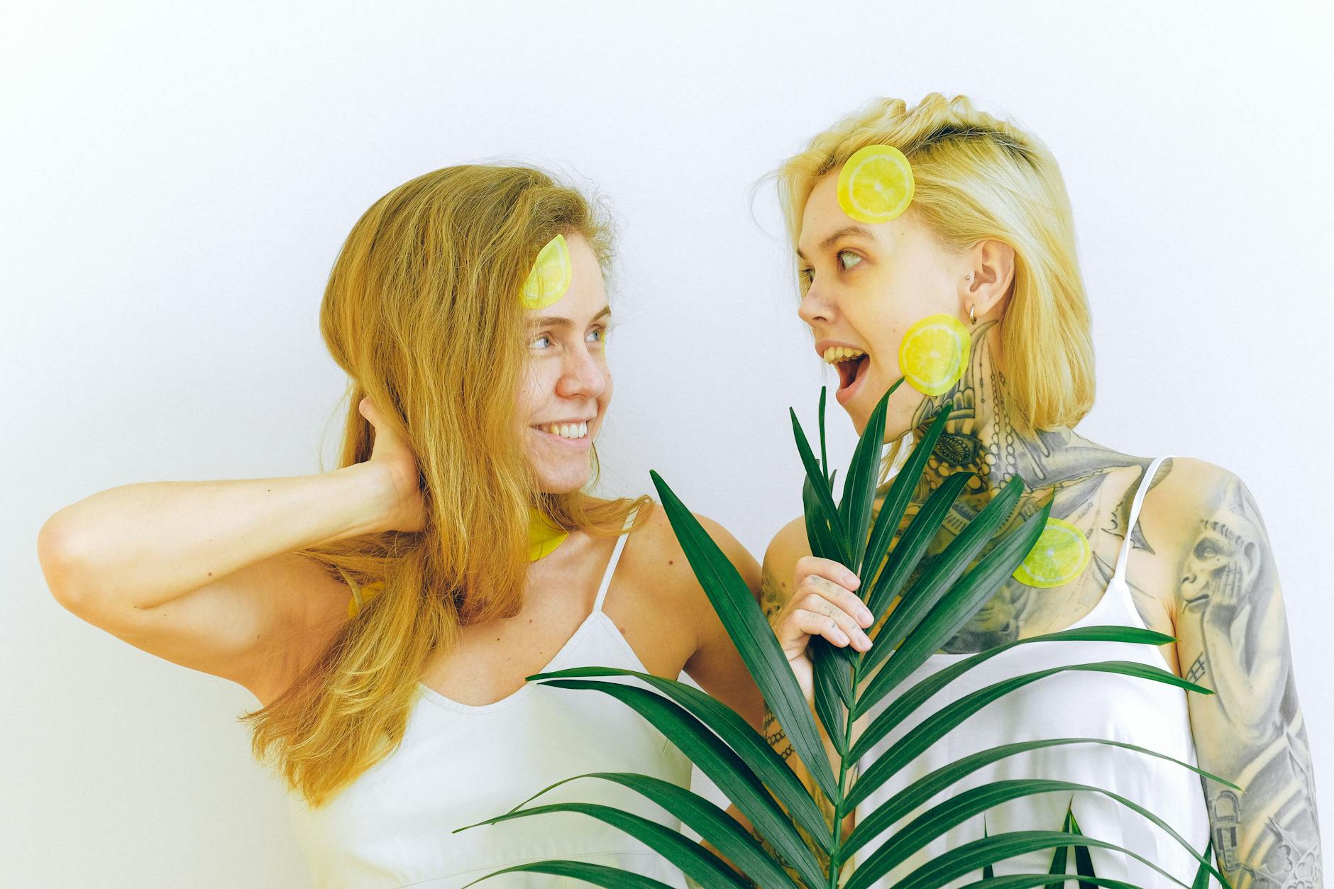 Two women smiling together indoors with lemon slices, expressing comfort and openness