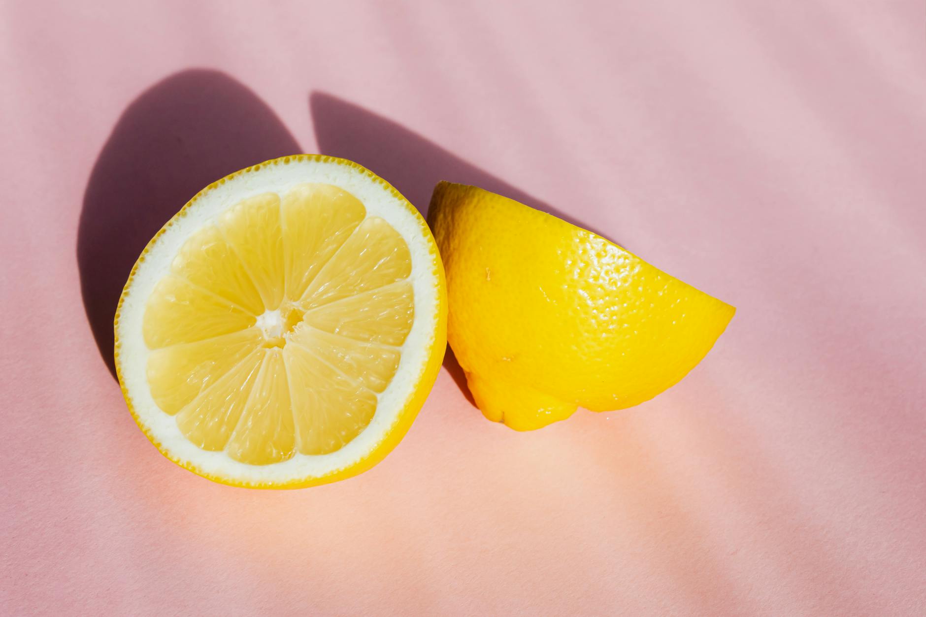 Three colorful lemon clitoral vibrators arranged on white fabric, highlighting smooth texture and design