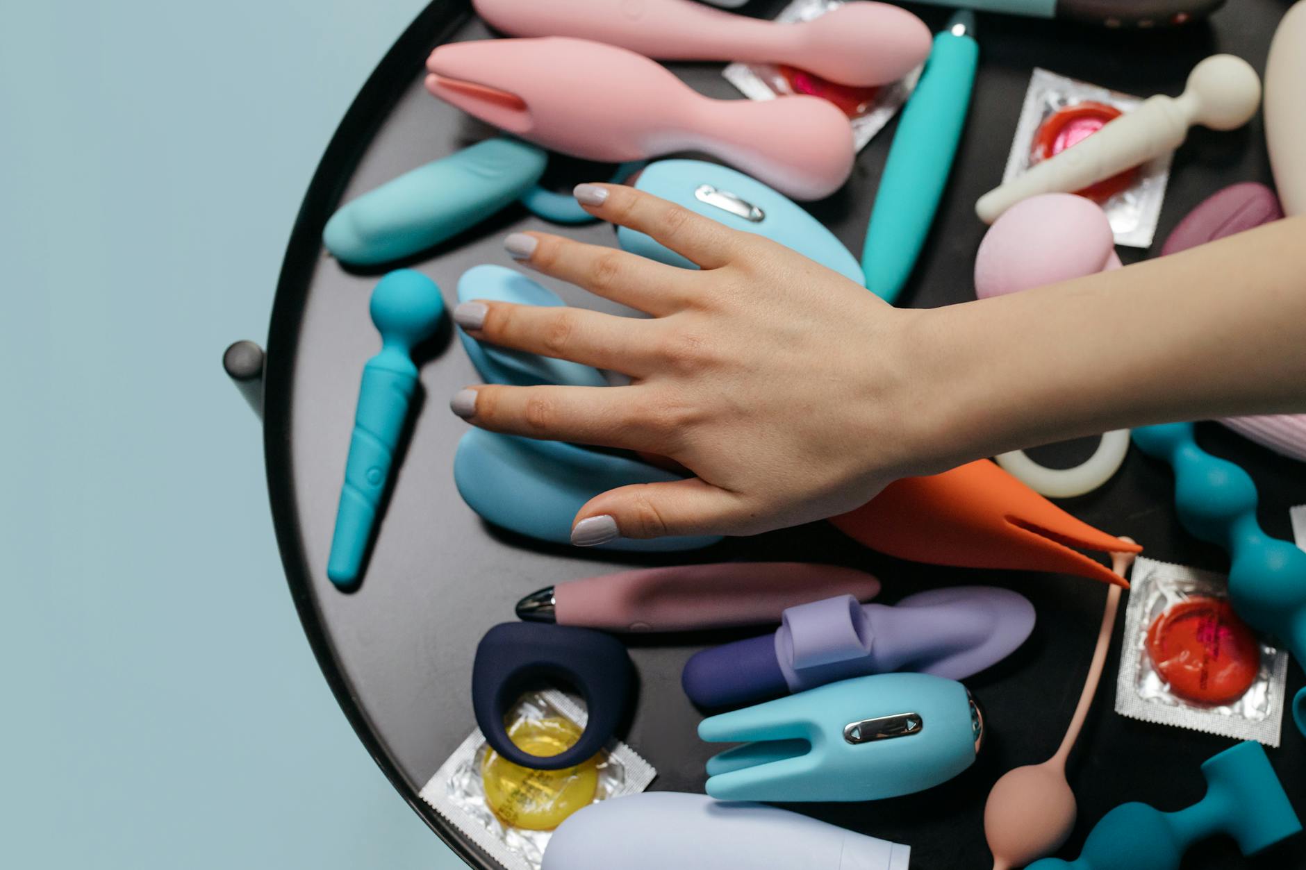 Intimate close-up of hands holding a sleek lemon vibrator between partners