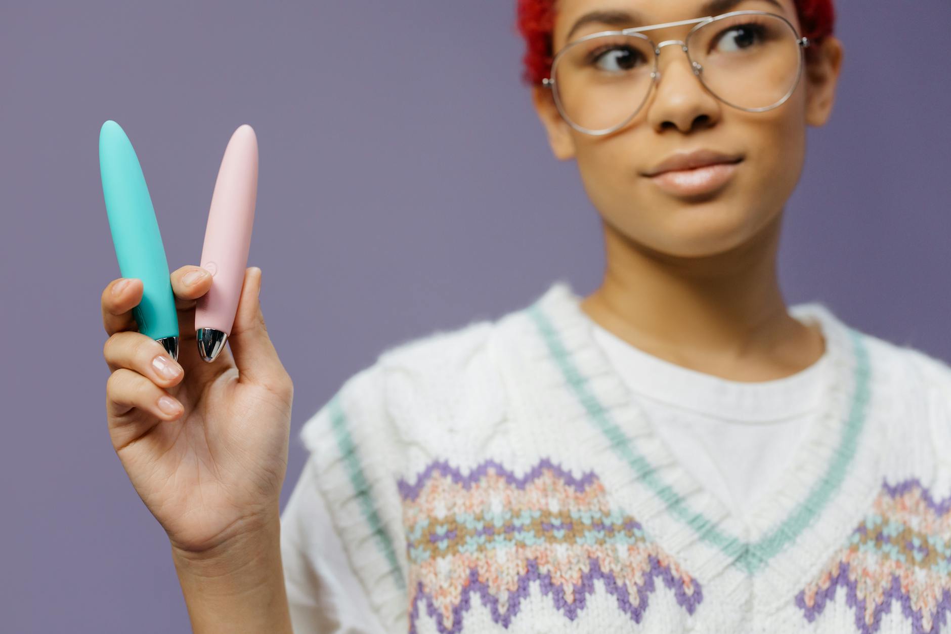 Two colorful lemon vibrators held against a purple background