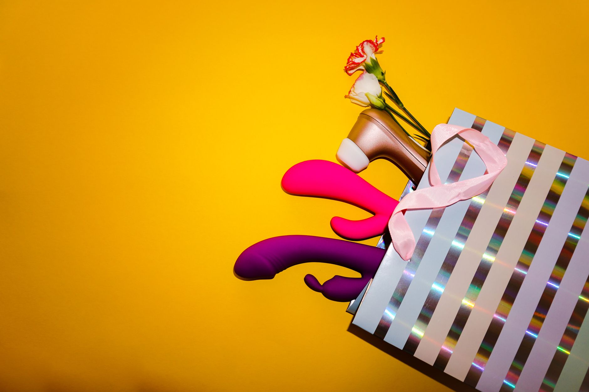 Person holding a blue silicone vibrator against a purple background, demonstrating intimate self-pleasure